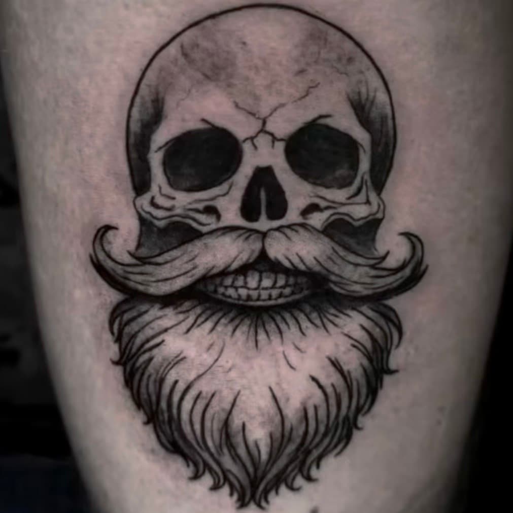 Tatuaje tradicional de calavera con barba en blackwork, por Samuel